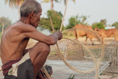 Asyalı yaşlı adam yapma bambu hasır kırsal kesimde.