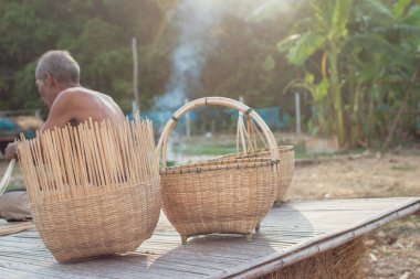 Asyalı yaşlı adam yapma bambu hasır kırsal kesimde.