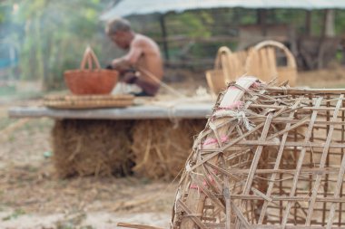 Asyalı yaşlı adam yapma bambu hasır kırsal kesimde.