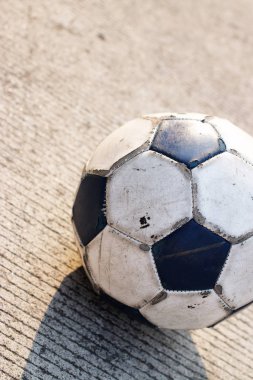 Kirli futbol topu beton yolda izole