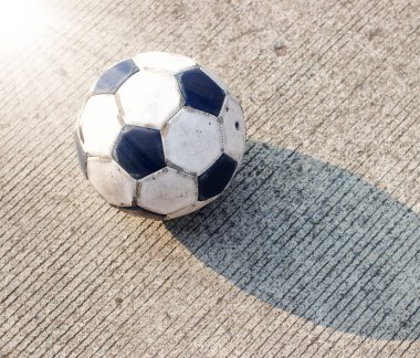 Kirli futbol topu beton yolda izole