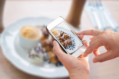 Smartphone tutan adamın elini kapatmak ve gıda fotoğrafını çekin