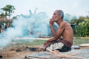 Yaşlı adam smok oturuyordu