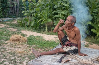 Yaşlı adam smok oturuyordu