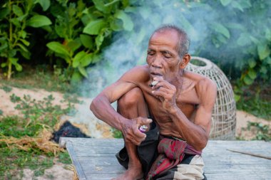 Yaşlı adam smok oturuyordu