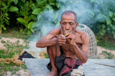 Yaşlı adam smok oturuyordu