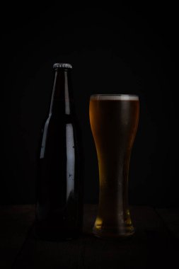 Koyu arkaplanda bir bardak bira