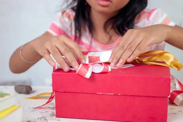 Ázsiai kislány csomagolás díszdobozban, ünnep ünnep karácsonyi anyák napi koncepció. — Stock Fotó