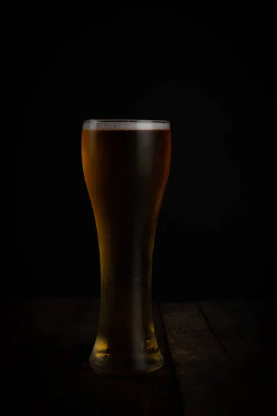 Egy pohár sör sötét háttérrel. — Stock Fotó