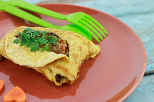 Gevulde omelet, Omelet met plantaardige salade en hart-vormige wortel, op blauwe oude houten — Stockfoto