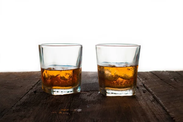 Glas Scotch-Whisky mit Eis auf Holztisch und weißem Hintergrund — Stockfoto