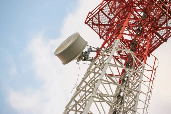 Wireless Communication Antenna Transmitter. Telecommunication tower with antennas on blue sky background.