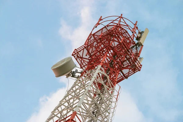 Wireless Communication Antenna Transmitter. Telecommunication tower with antennas on blue sky background.