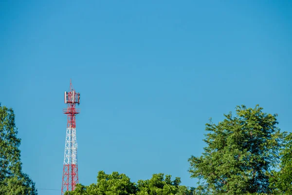 Wireless Communication Antenna Transmitter. Telecommunication tower with antennas on blue sky background.