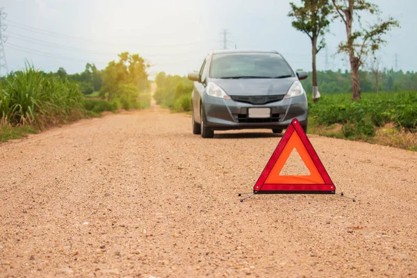 Red warning triangle. Focus on red triangle!, beside rural road.