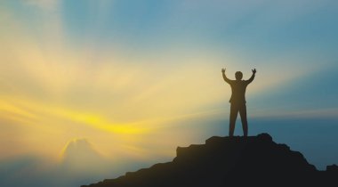 Dağın tepesindeki insan silueti gökyüzü ve güneş ışığı arkaplanı, iş dünyası, başarı, liderlik, başarı ve insanların kavramı