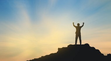 Dağın tepesindeki insan silueti gökyüzü ve güneş ışığı arkaplanı, iş dünyası, başarı, liderlik, başarı ve insanların kavramı
