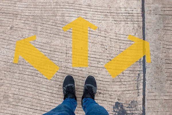 Person Wearing Sneakers Standing Concrete Road Yellow Arrows Decision Making — Stock Photo, Image