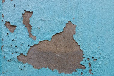 Terk edilmiş evdeki eski boya tabakalarıyla çatlamış bir duvar.