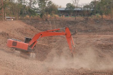 Turuncu ekskavatör Yapım aşamasında Büyük rezervuar, Toz toprak kazma tarafından.