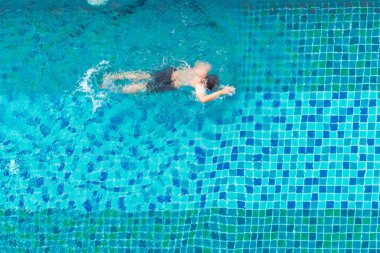 Yüzme havuzunda yüzen bir adamın yüksek açılı görünümü