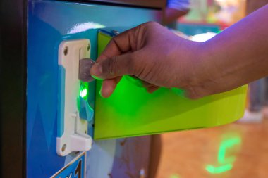 El, alışveriş merkezinde çocukların oyun konsoluna bozuk para ekle