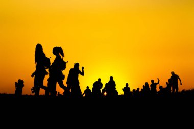 Birçok turist siluet gün batımı saatlerinde dağın tepesinde akıllı telefon ile fotoğraf çekiyor.