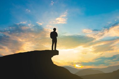 gökyüzü ve güneş ışığı arka plan üzerinde dağ üstünde backpacker silueti, iş, başarı, liderlik, başarı ve insan kavramı