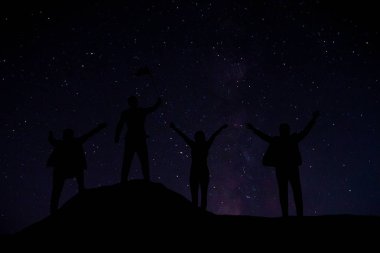 Başarılı insanlar zirvede bulunuyor. Gece gökyüzündeki güzel yıldızların arasında.