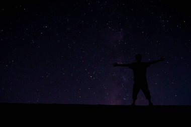 Zirvede başarılı bir adam. Gece gökyüzündeki güzel yıldızların arasında.