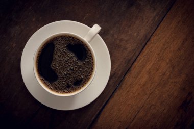 Ahşap arka planda bir fincan kahve. Uzayı kopyala Üst Manzara. Düz yatıyordu