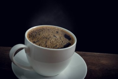 Eski ahşap masada bir fincan kahve.