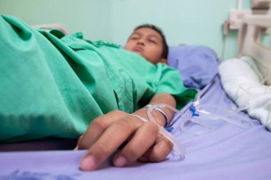 Hastanedeki hastanın yatağında yatan çocuk.