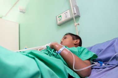 Hastanedeki hastanın yatağında yatan çocuk.