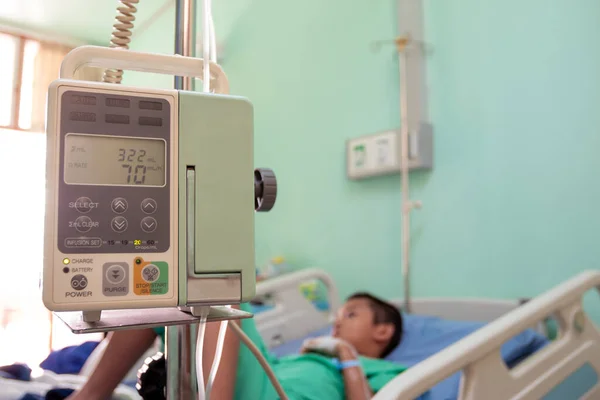 An Asian boy is treating a patient in a hospital bed.