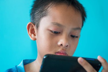 Çocuk akıllı telefonundan Corona virüsü haberlerini okuyor..