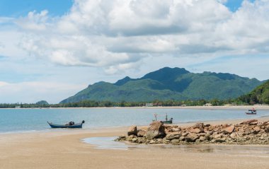 Balıkçı teknesi plaj ve yeşil tepe ve deniz ve resif veya kaya üzerinde mavi. Balıkçı tekne veya yaz konsepti Prachuap Khiri Khan, balıkçı teknesi