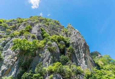 Taş veya rock dağ ya da tepe yeşil ağaç ve mavi gökyüzü ve su ve bulut, Khao Dang ile kanal Prachuap Khiri Khan Tayland. Manzara veya