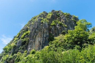 Taş veya rock dağ ya da tepe yeşil ağaç ve mavi gökyüzü ve su ve bulut, Khao Dang ile kanal Prachuap Khiri Khan Tayland. Manzara veya