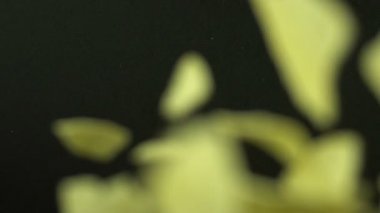 Yavaş hareket Fallen veya Droped patates cipsi veya aperatif ve çatlak veya siyah arka plan üzerinde kırdı. Düşmüş patates cipsi ya da aperatif yiyecek reklam için. Tam HD 1920 x 1080 yüksek çözünürlüklü görüntüleri