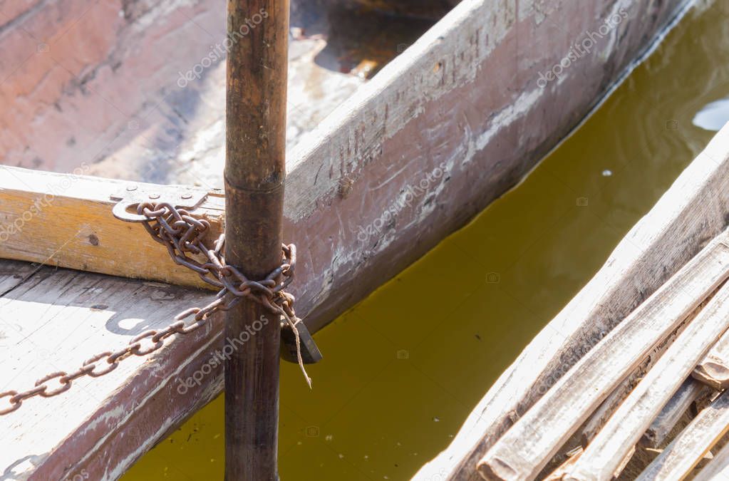 Wood Fishing Boat is Enchained by Iron Chain with Wood Boat Pole