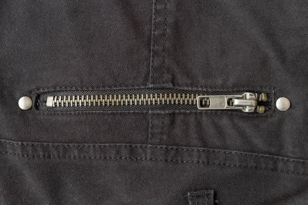 Gesloten messing ritssluiting op zwarte jeans textuur achtergrond — Stockfoto