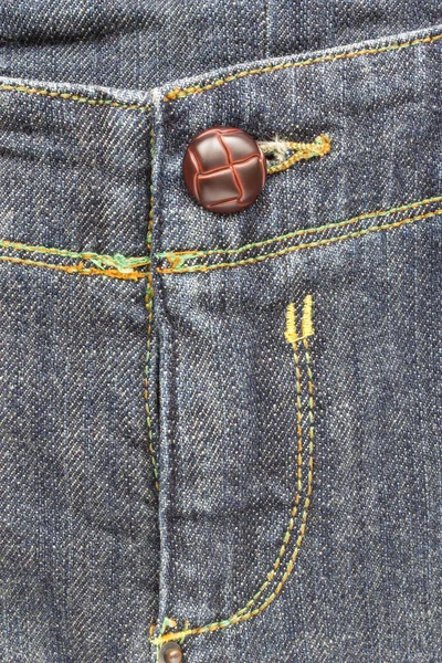 Kruis jeans textuur achtergrond en bruine knop — Stockfoto