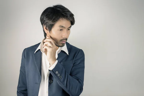 Portrait Man in Navy Blue Suit Looking Below and Touch Chin Pose