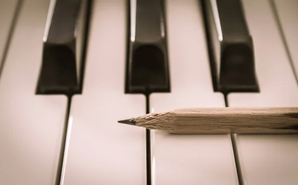 水平ビューのエレクトリックピアノの白いキーに古い鉛筆 — ストック写真