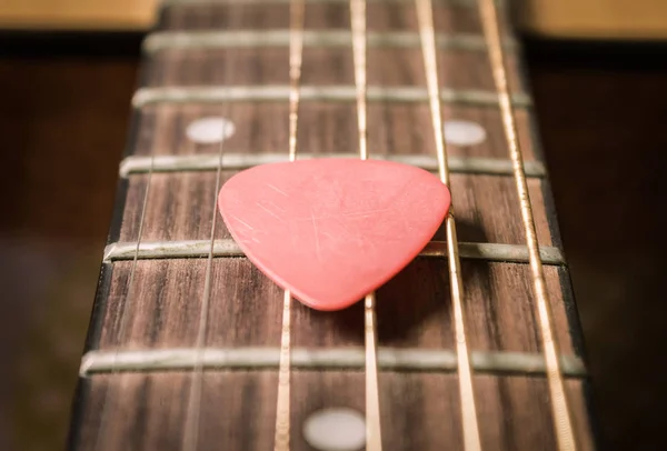 Röd Pick på akustisk gitarrsträng i Vintage Tone — Stockfoto