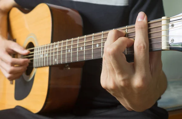 Рука гітариста в F Major Chord на акустичній гітарі в бік V — стокове фото