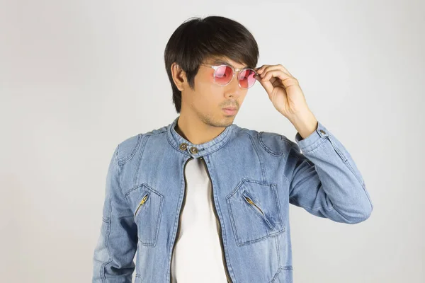 Молодой азиат в джинсах или джинсовой куртке коснулся красных очков и L — стоковое фото