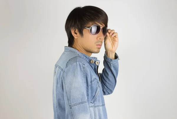 Joven hombre asiático en pantalones vaqueros o gafas de sol Denim Jacket Touch en Tur — Foto de Stock