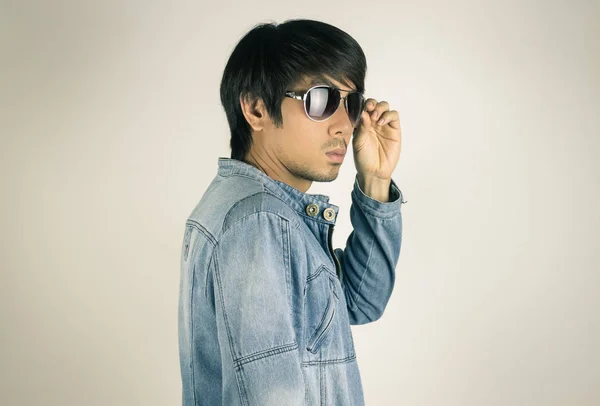 Ung asiatisk man i jeans eller jeansjacka touch solglasögon i tur — Stockfoto